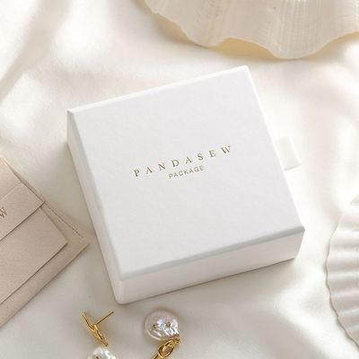 La petite glissière chic de boîte d'emballage de bijoux de carton s'ouvrent avec l'extracteur de satin